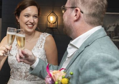 Bruid en bruidegom proosten met champagne