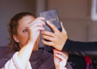 Bruid bekijkt haar make-up in een handspiegel