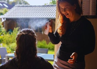 Susanne verzorgt het haar van een zittende klant