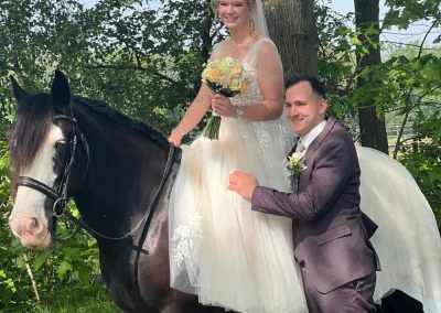 Bruid op een zwart paard naast de bruidegom