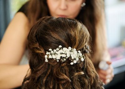 Susanne plaatst een haaraccessoire in half opgestoken krullen