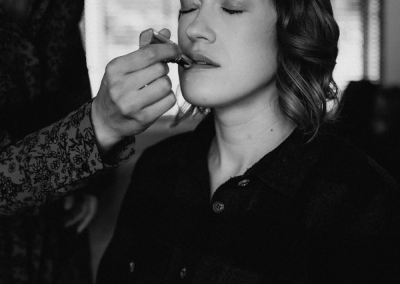 Zwart-witfoto van het aanbrengen van bruidsmake-up