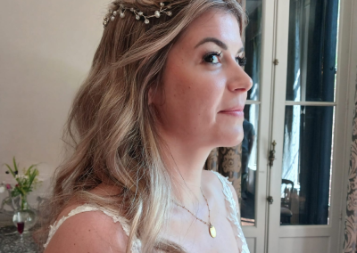 Bruid met blonde krullen en een subtiel haaraccessoire